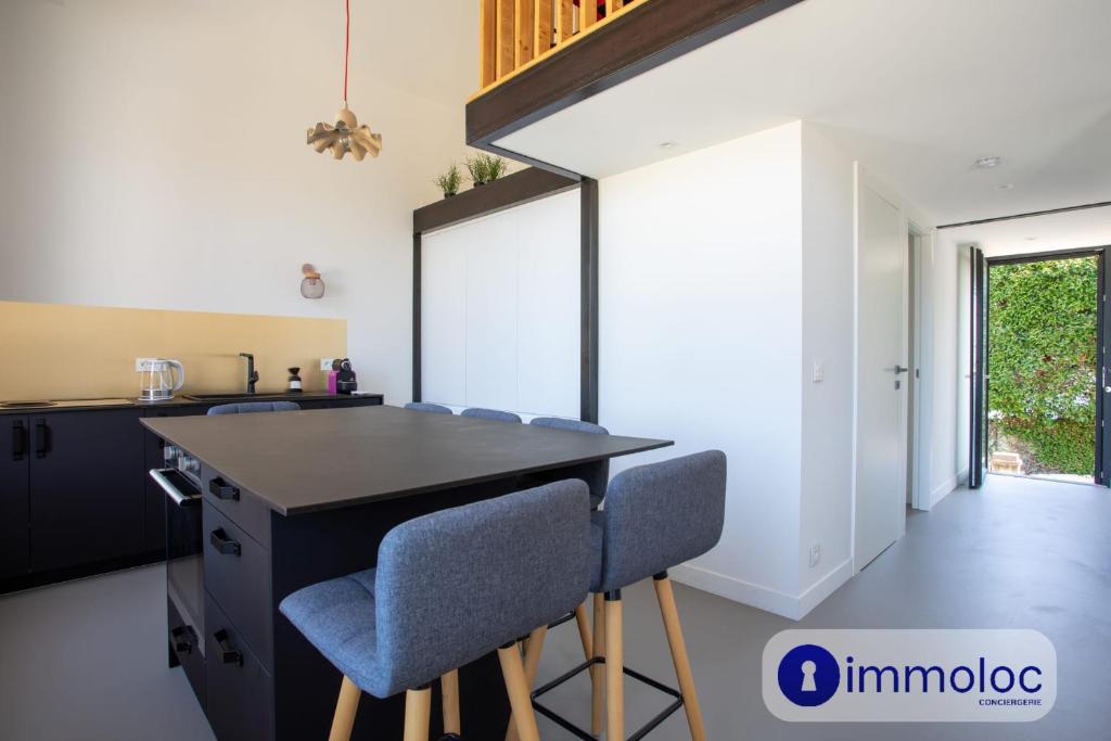 une cuisine avec un comptoir noir et des chaises bleues dans l'établissement Apartment T3 air-conditioned in house neighborhood Cimiez, à Nice