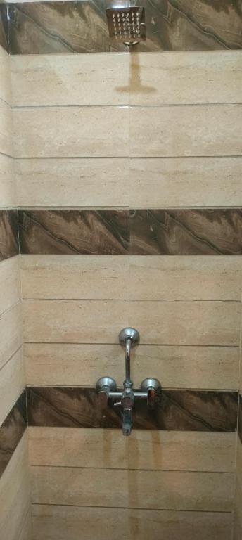 um teto de banheiro com uma torneira de água de metal em Bed and Breakfast at Colaba em Mumbai