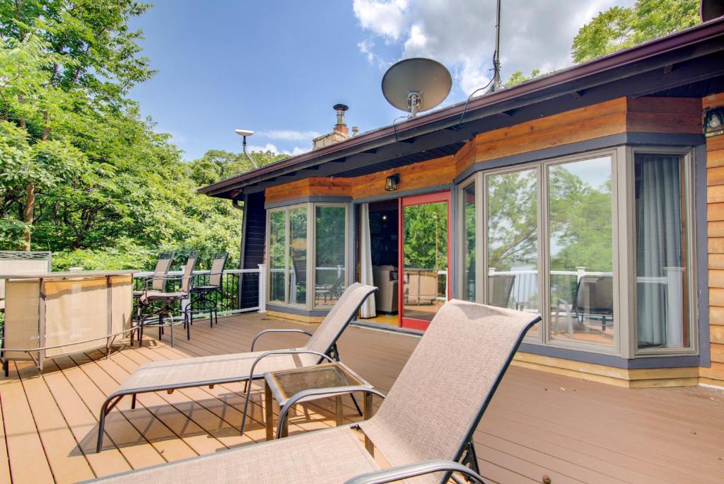 a deck with chairs and tables on a house at Walk to Tuttle Creek Lake Secluded Scenic Retreat in Manhattan