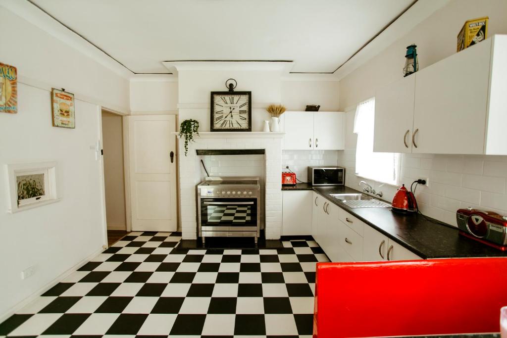 uma cozinha com piso em xadrez preto e branco em King Cottage em Windsor