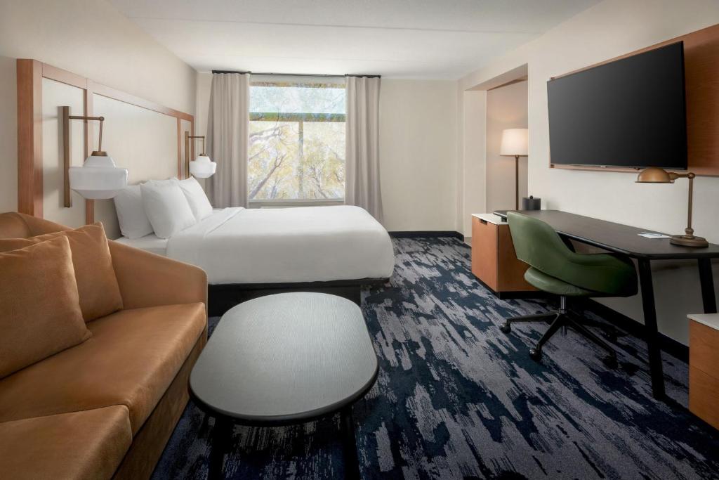 Cette chambre comprend un lit, un bureau et un canapé. dans l'établissement Fairfield by Marriott Inn & Suites Rome NY, à Rome