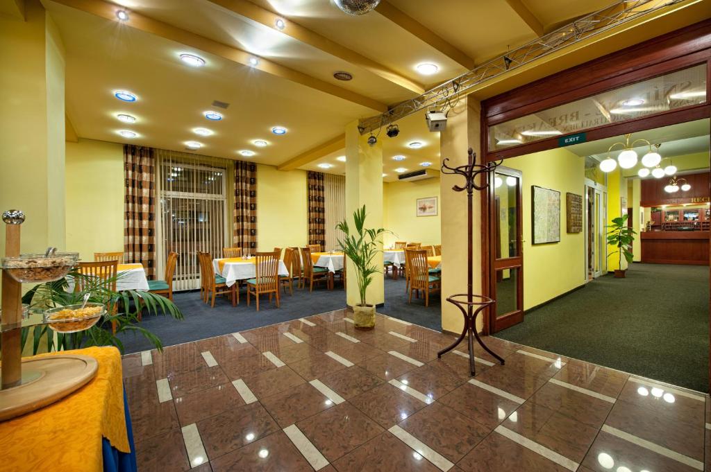 a lobby of a restaurant with tables and chairs at Hotel Henrietta in Prague