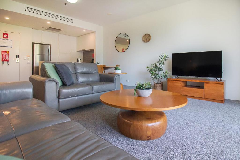 sala de estar con sofá y mesa en 325 Harbour Lights with Garden View en Cairns