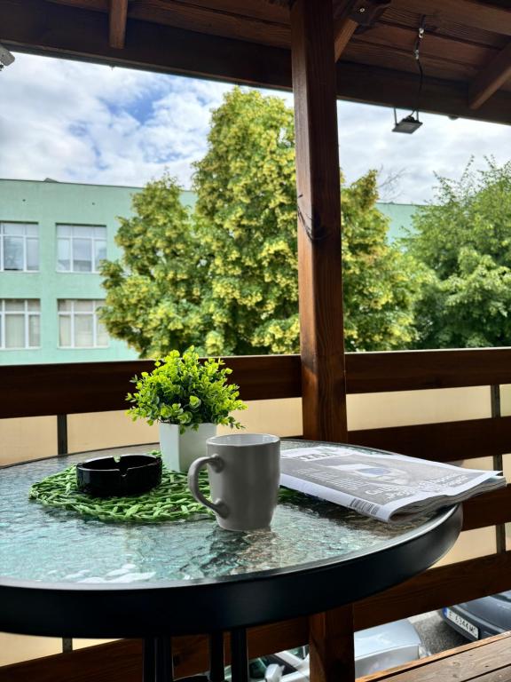 einen Tisch mit einer Kaffeetasse auf dem Balkon in der Unterkunft Apartment Alex in Sandanski