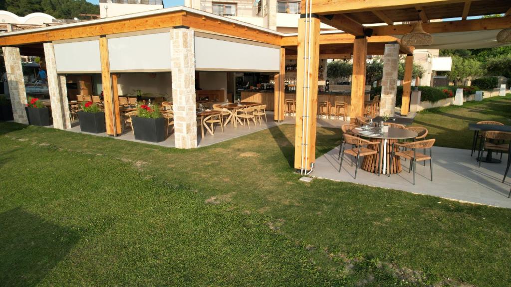 an outdoor patio with tables and chairs in a yard at Olympion Sunset Halkidiki in Fourka
