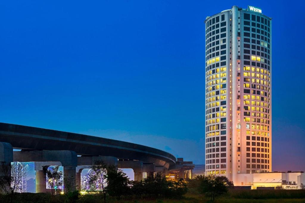 um edifício alto com luzes acesas em frente em The Westin Kolkata Rajarhat em Calcutá