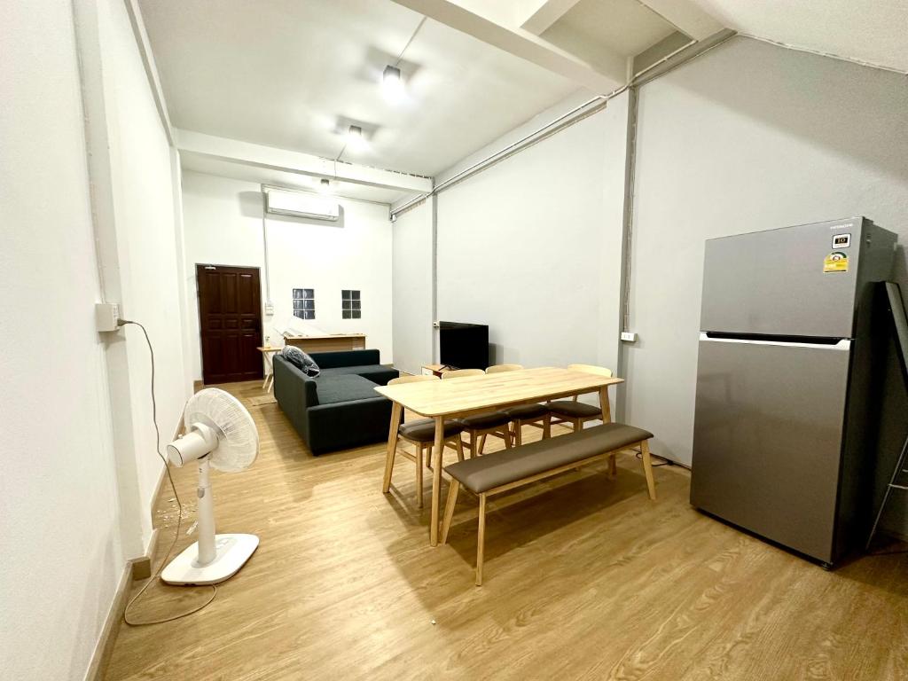 ein Wohnzimmer mit einem Tisch und einem Kühlschrank in der Unterkunft Bee House 172 only 300m to BTS Talat Phlu in Bangkok