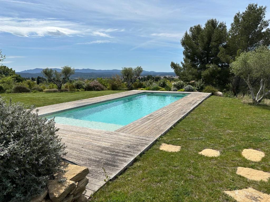 - une piscine dans une cour avec une terrasse en bois dans l'établissement Studio Verveine, à Aix-en-Provence
