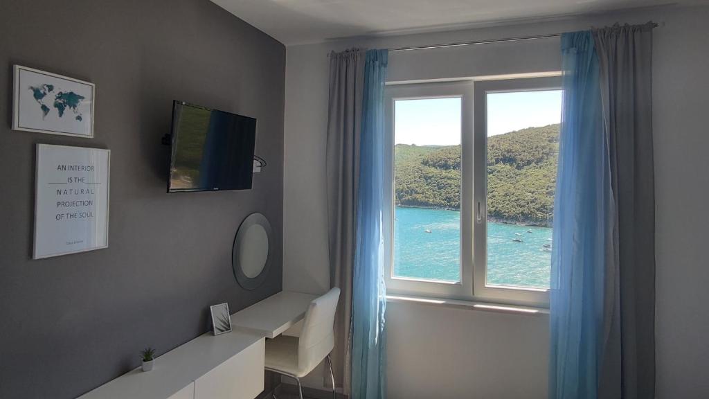 een kamer met een raam met uitzicht op de oceaan bij Apartment Noemi with a direct beach view in Rabac