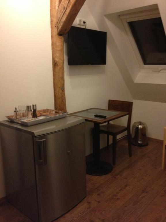 eine Küche mit einem Tisch und einem TV an der Wand in der Unterkunft Old Town Guesthouse Erlangen in Erlangen
