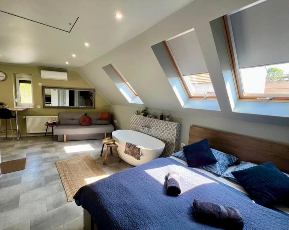 a bedroom with a bed and a bathroom with skylights at Eger's Flow Apartment in Eger