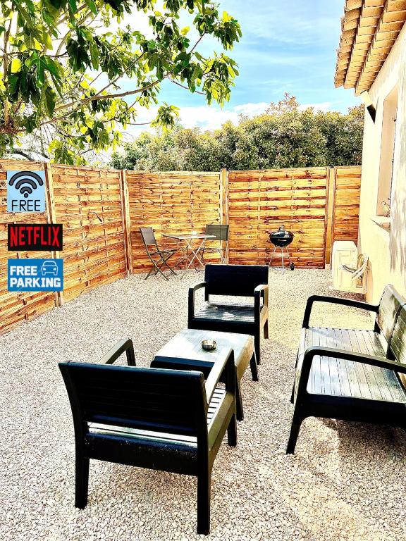 un groupe de chaises et de tables sur une terrasse dans l'établissement Charment 2 Pièces indépendant villa, à Mougins
