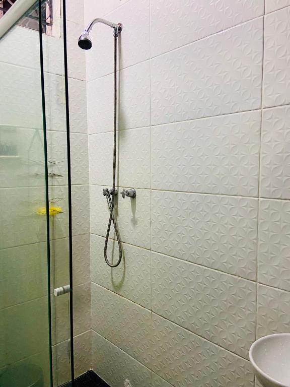 um chuveiro com uma porta de vidro na casa de banho em Galeria SP Hostel em São Paulo