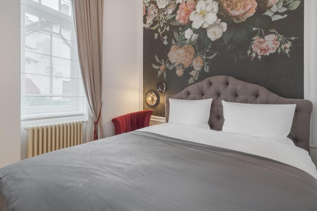 1 dormitorio con 1 cama grande y papel pintado con motivos florales en Arta Residence, en Oradea