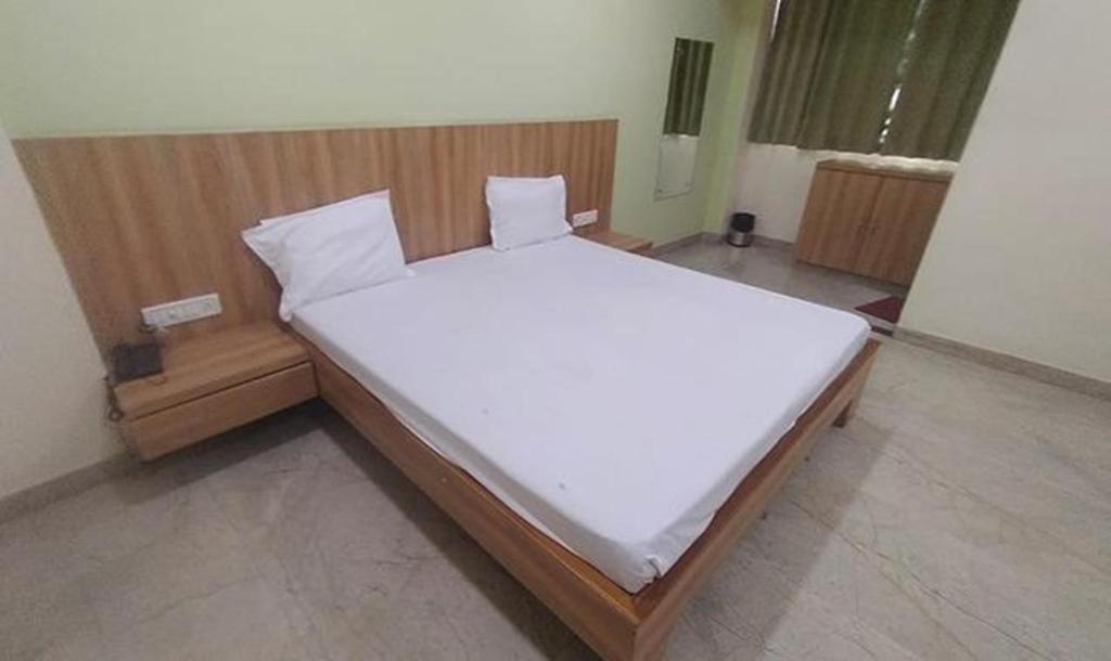 a bedroom with a large bed with white sheets at FabHotel Park Mahindra in Raipur