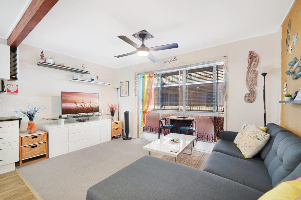 sala de estar con sofá y TV en Two-bedroom Beachside Apartment with Parking en Gold Coast