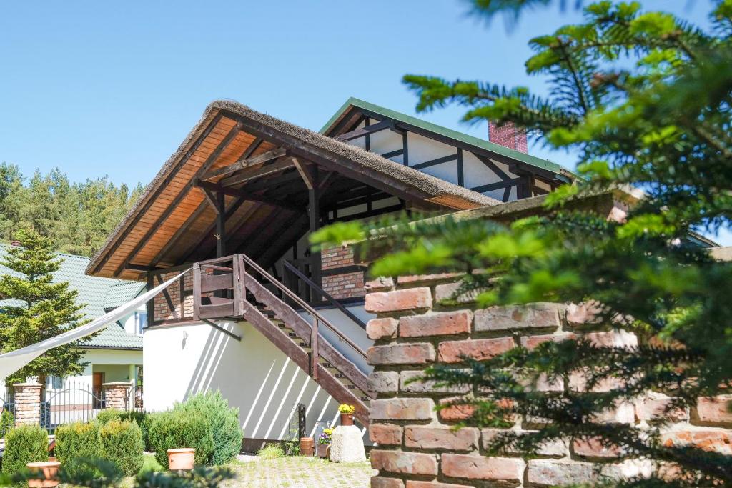 dom z drewnianym dachem i schodami w obiekcie Nadmorska Strzecha w Smołdzińskim Lesie
