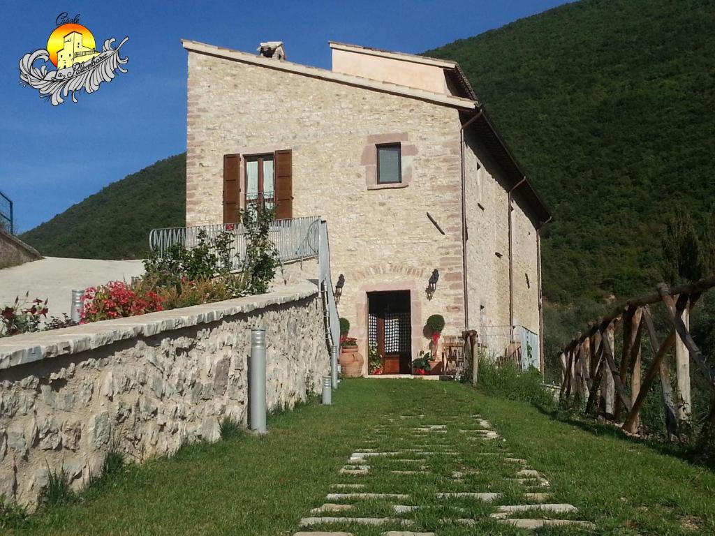 a stone house with a stone wall next to a building at Agriturismo Casale La Palombara in Cerreto di Spoleto
