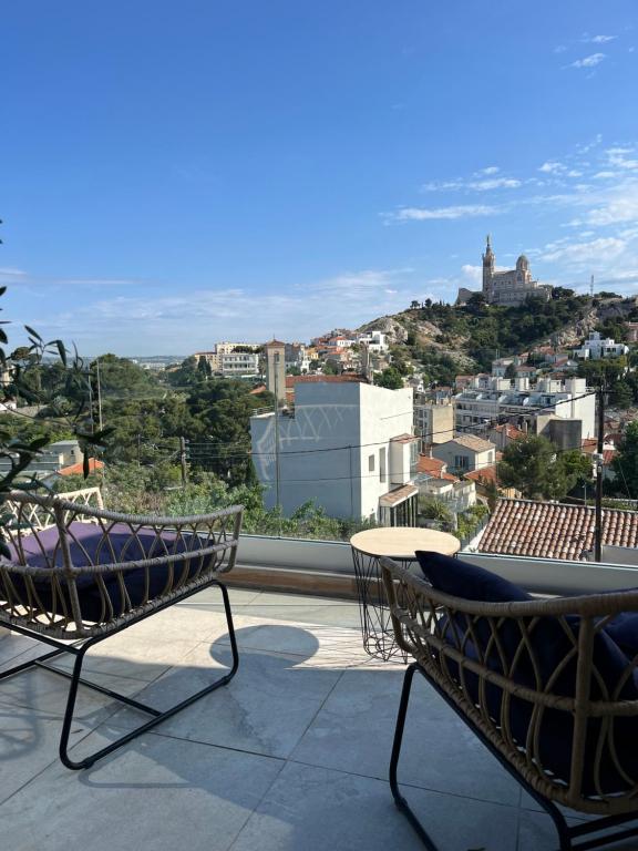 2 Stühle und ein Tisch auf einem Balkon mit Aussicht in der Unterkunft Les Balcons du Roucas Blanc in Marseille