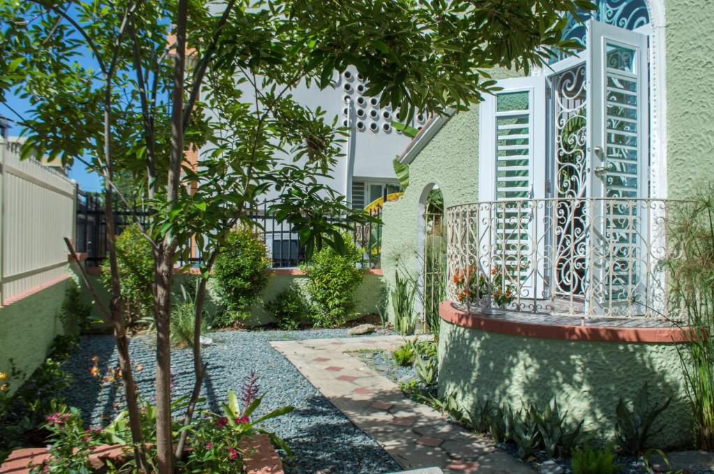 a garden with a fence and trees in front of a building at Casa Isabel B&B in San Juan