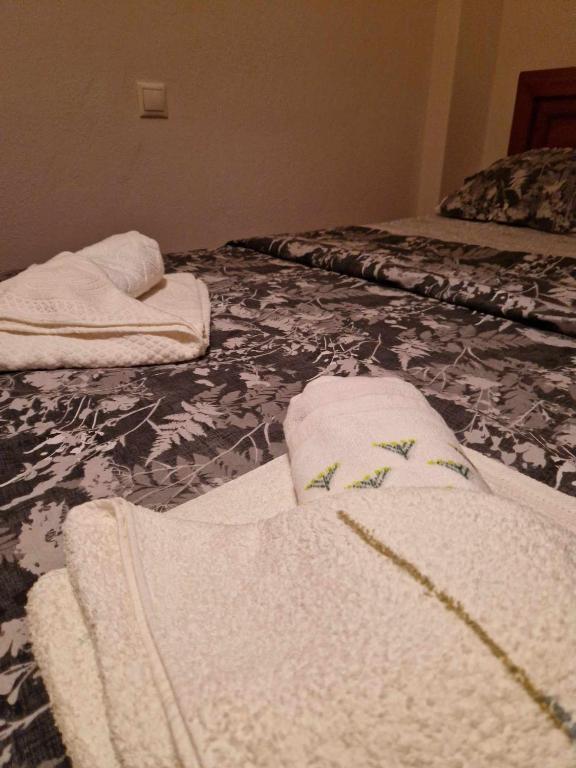 two white towels are sitting on a bed at Efchi city center apartment in Katerini