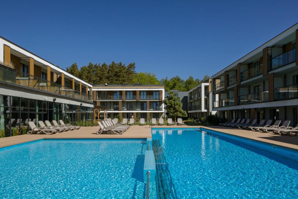 a large swimming pool in front of a building at Hotel Saltic Resort & Spa Grzybowo in Kołobrzeg