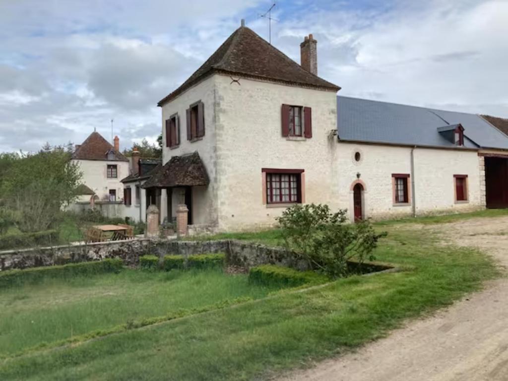 an old white house with a yard and a dirt road at Gîte très grande famille Les Gaschetières in Lailly-en-Val