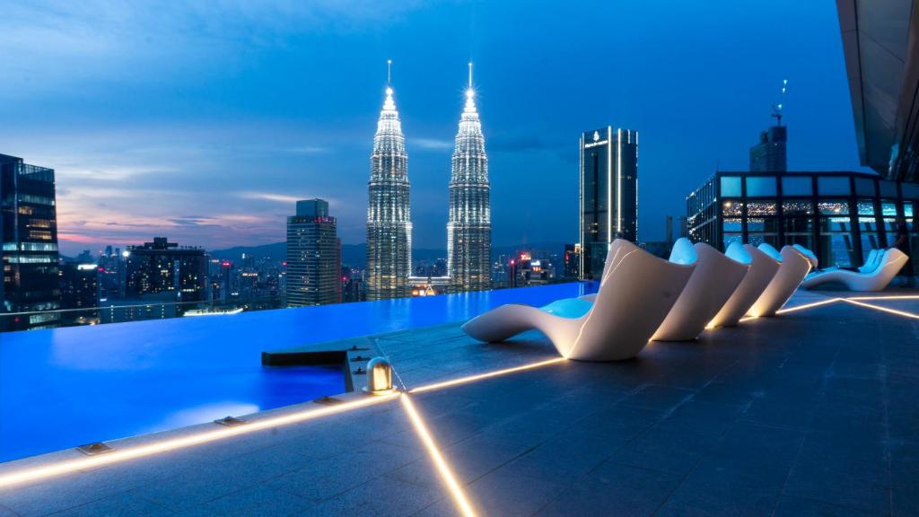 uma fila de cadeiras brancas sentadas em cima de um edifício em Imperial Luxury Suites KLCC by Moonway em Kuala Lumpur