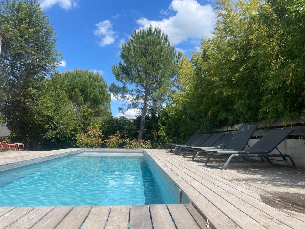 basen z leżakami na drewnianym tarasie w obiekcie Villa (Loft) à Villetelle, 20 mn des plages w mieście Villetelle