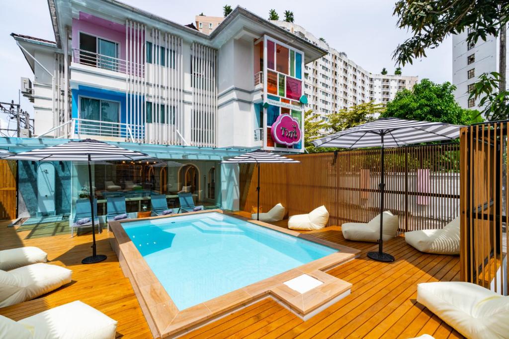 プーケットタウンにあるThe Tint At Phuket Town - SHA Plusの木製デッキのパラソル付きスイミングプール