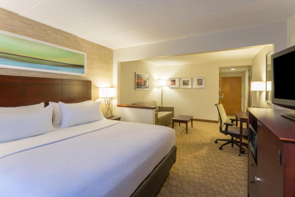 a hotel room with a large bed and a desk at Holiday Inn Baltimore BWI Airport by IHG in Linthicum Heights