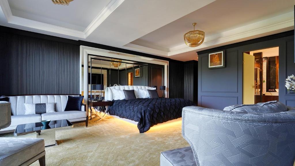 a bedroom with a bed and a couch and chairs at Imperia Luxury Residence in Braşov