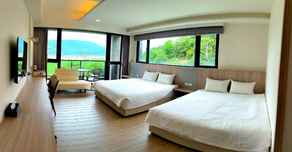 sypialnia z 2 łóżkami i pokój z oknami w obiekcie 宜荷山宿 w mieście Datong