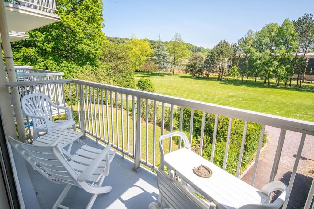 - un balcon avec 2 chaises, une table et un champ dans l'établissement Calme et sérénité - Balcon - Parking 1 place, à Étretat