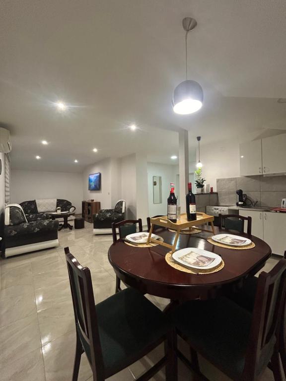ein Esszimmer und ein Wohnzimmer mit einem Tisch und Stühlen in der Unterkunft Apartman Diamond Lux in Surčin