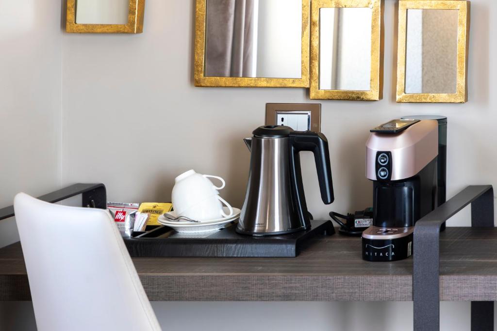 a table with a coffee maker and a coffee pot on it at Milestone in Quartu SantʼElena