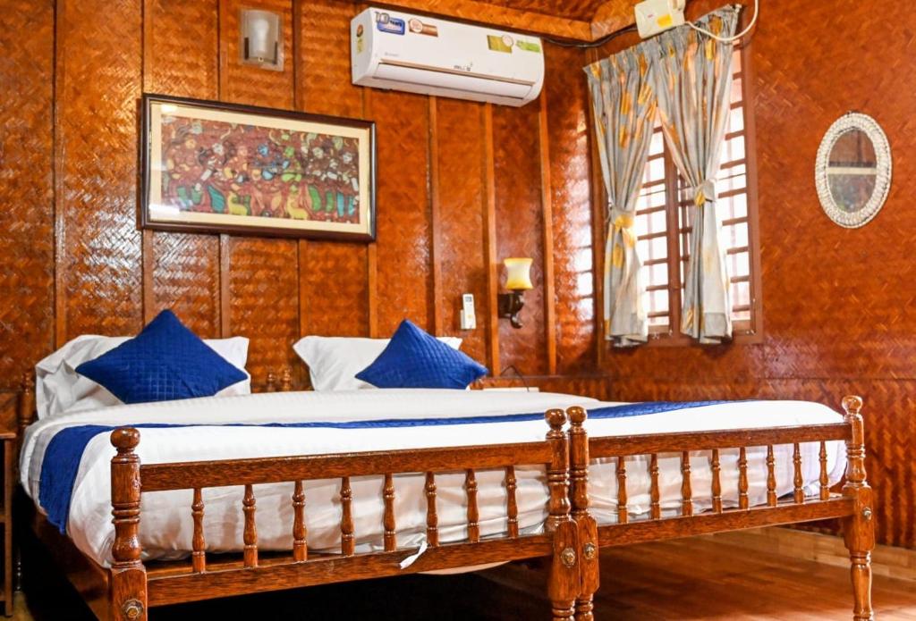 a bedroom with a bed with blue pillows at Sajeev Home Stay in Cherai Beach