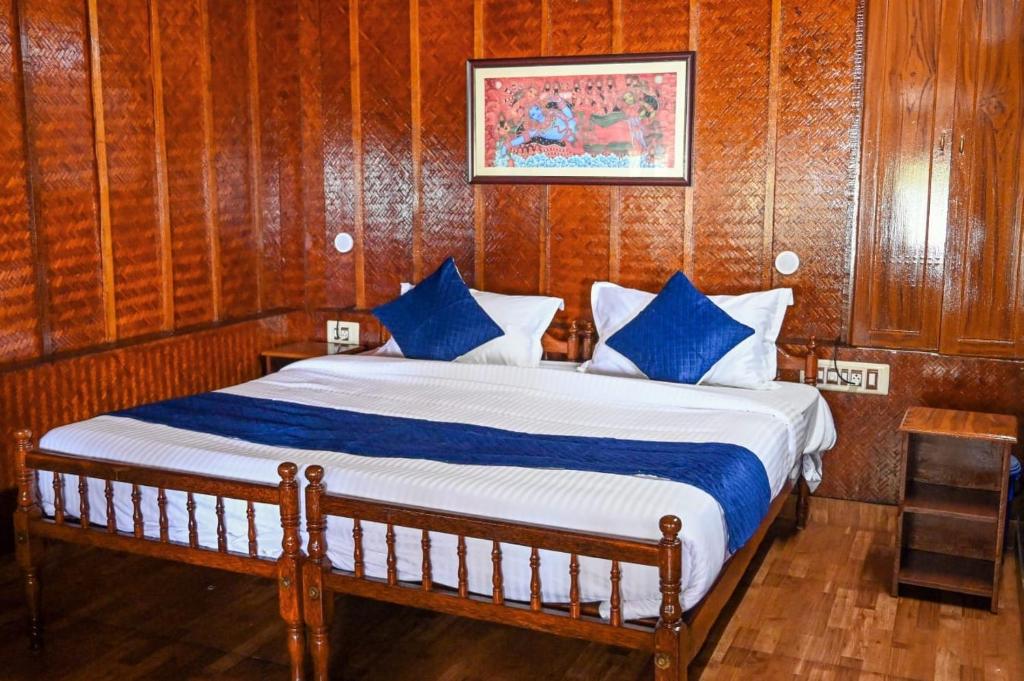 een slaapkamer met een bed met blauwe kussens bij Sajeev Home Stay in Cherai Beach