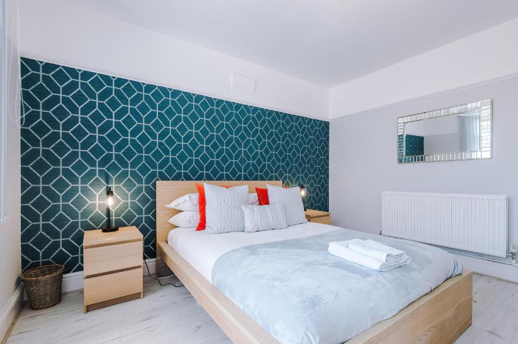 a bedroom with a bed and a green wall at "Eastville Court Rhyl" by Greenstay Serviced Accommodation - Cosy 2 Bedroom Bungalow with Parking, Netflix & Wi-Fi, Close To Beaches, Shops & Restaurants - Ideal for Families, Business Travellers & Contractors in Rhyl