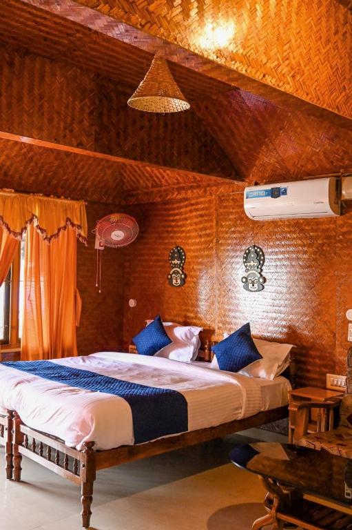 a bedroom with a large bed with blue pillows at Sajeev Home Stay in Cherai Beach