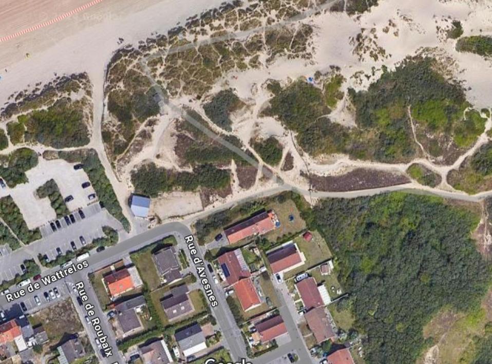 - une vue sur une plage avec des bâtiments et l'océan dans l'établissement Maison bord de mer, à Zuydcoote