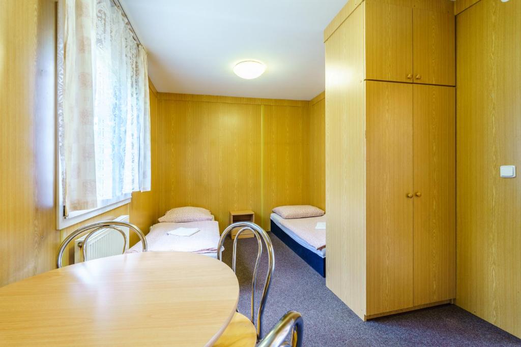 Pokój z 2 łóżkami, stołem i krzesłami w obiekcie Apartmány Nová Role - BeachCamp w mieście Nová Role