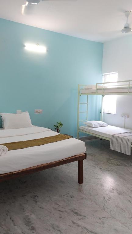 2 Etagenbetten in einem Zimmer mit blauen Wänden in der Unterkunft 26 LaPorte in Puducherry