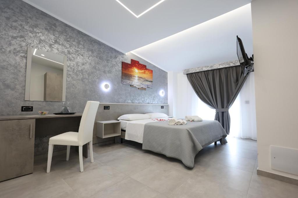 a bedroom with a bed and a desk and a chair at B&B Sunlight Tropea in Tropea