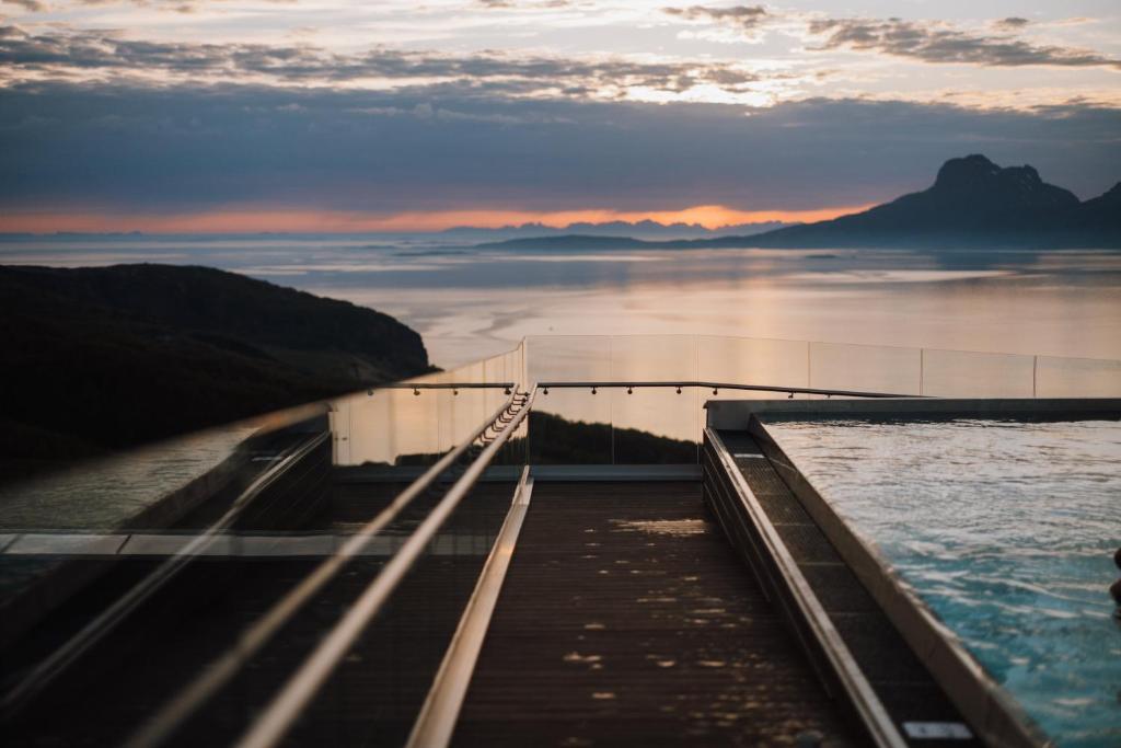 un puente sobre un cuerpo de agua al atardecer en Wood Hotel Bodø en Bodø