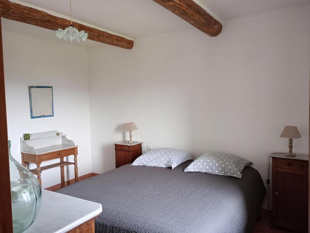 um quarto com uma cama e um lavatório em Le Lavoir em Lacoste