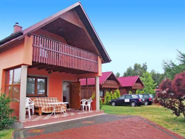 a house with a porch with a table and chairs at Camping Bałtyk in Dźwirzyno