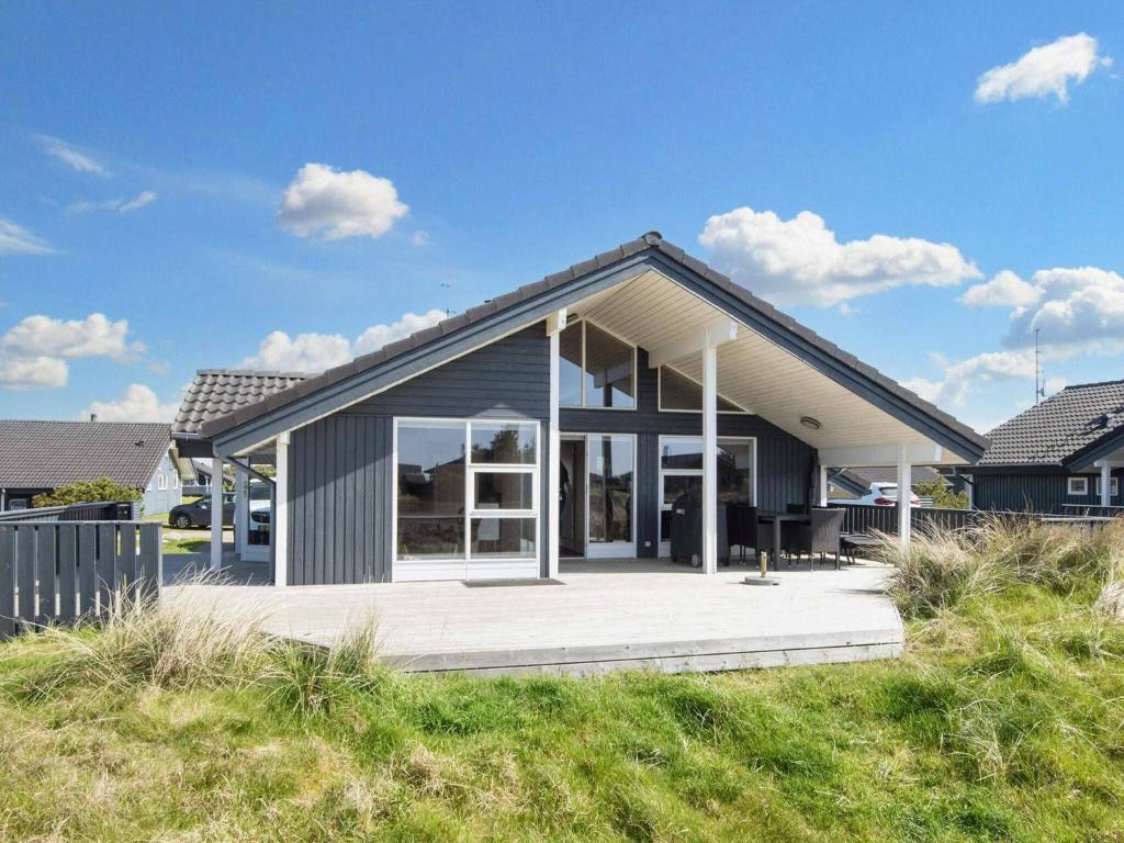 a house on the beach with a large patio at 6 person holiday home in Ringk bing in Ringkøbing
