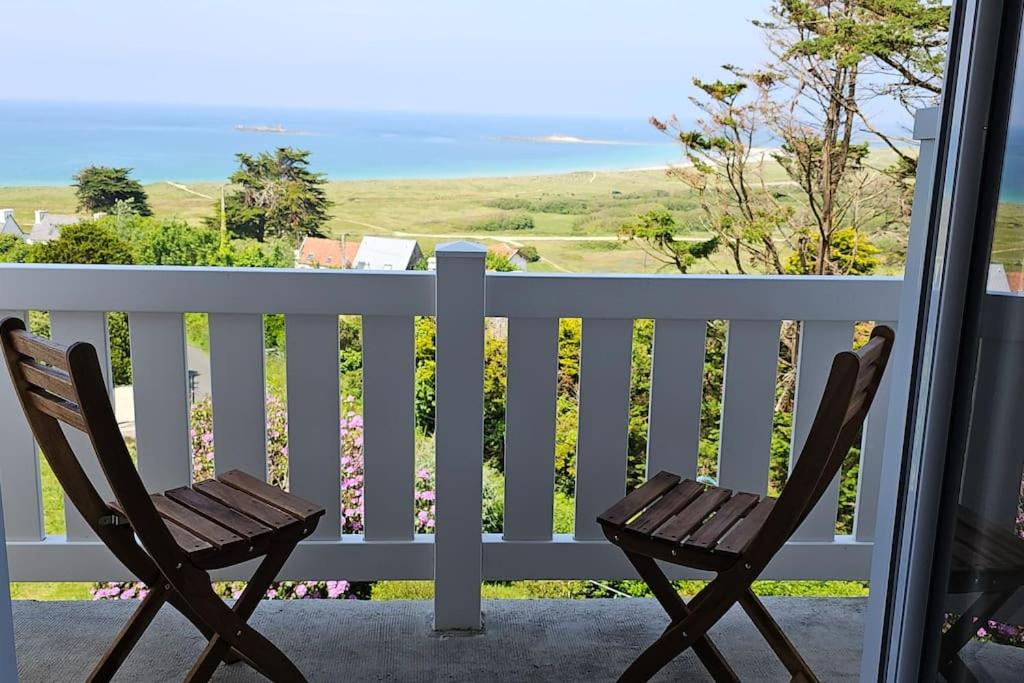 une paire de chaises assises sur une terrasse couverte donnant sur l'océan dans l'établissement Jolie maison avec vue mer imprenable proche plage, à Plouguerneau