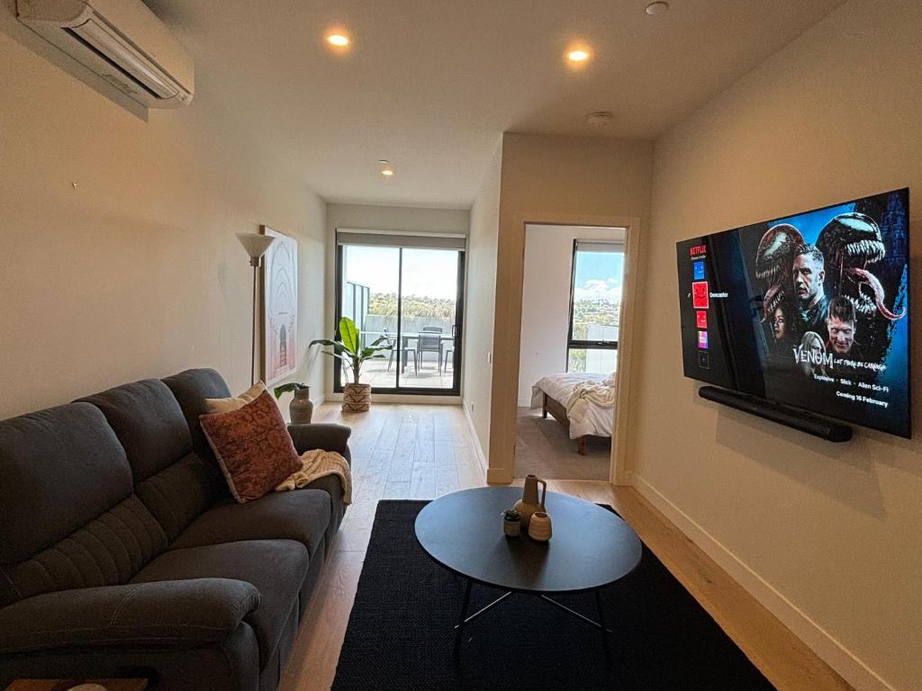 a living room with a couch and a flat screen tv at Entire 2Bd2bth Cosy Apartment Doncaster in Doncaster East